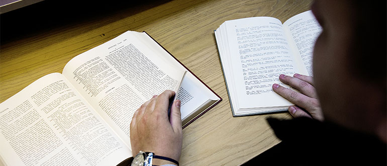 A student browsing in two books